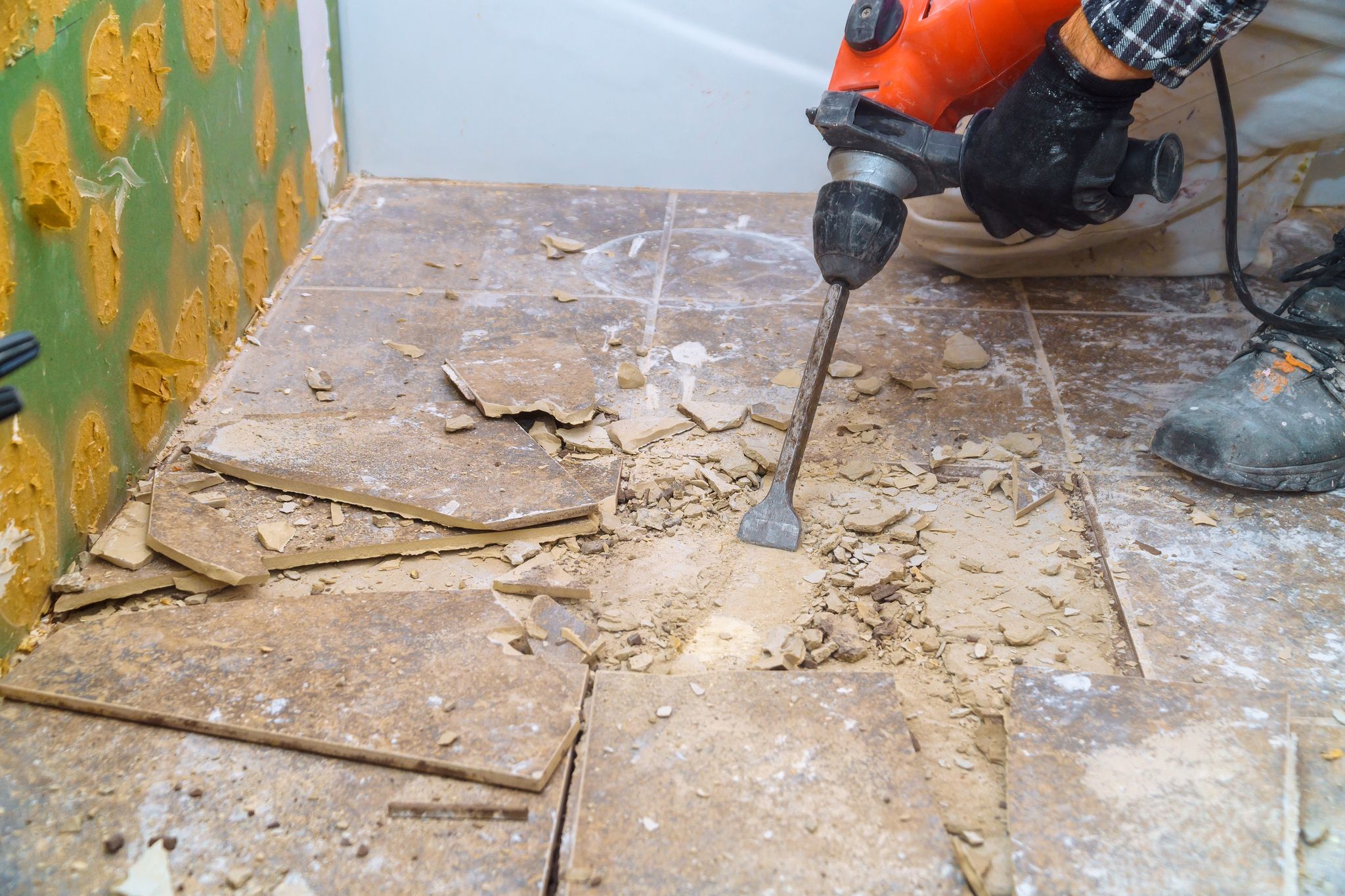 Worker remove, demolish old tiles in a bathroom with jackhammer
