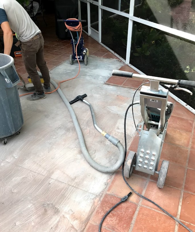 person cleaning a floor with a vacuum cleaner